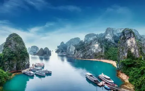 Zatoka Ha Long we Wietnamie z łodziami i skalistymi wyspami.