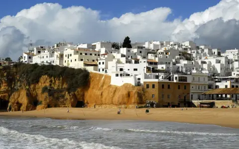 Białe domy na klifie, plaża i morze. Portugalia pogoda roczna, idealna na spacer.
