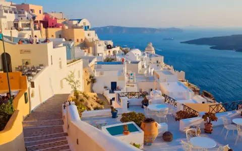 Białe domy na klifie z widokiem na błękitne morze, Santorini.