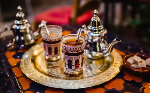 Tradycyjna herbata miętowa z cukrem, serwowana w ozdobnych szklankach i srebrnym imbryku. Idealna na czas Ramadanu, gdy pytamy "ramadan co to".