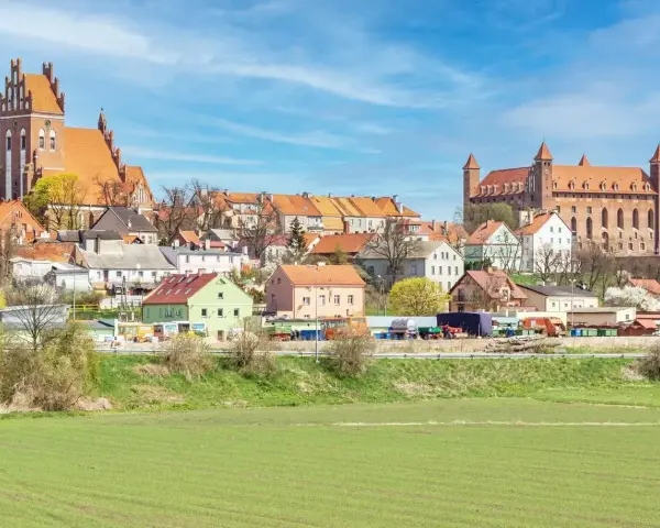 Zamek w Gniewie - ciekawostki. Imponująca twierdza i urokliwe miasteczko na tle błękitnego nieba.