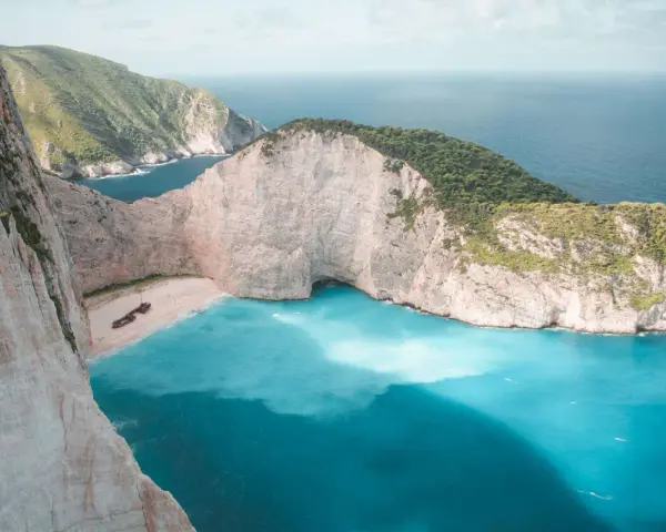 Zatoka Wraku na Zakynthos z turkusową wodą i klifami.