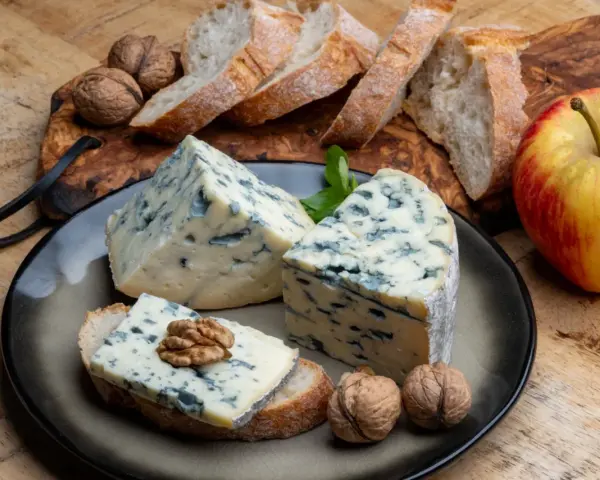 Kawałki sera gorgonzola z niebieską pleśnią, podane z chlebem, orzechami i jabłkiem. Idealne na przekąskę, która odpowie na pytanie: co to gorgonzola.