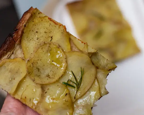 Pyszna pizza ziemniaczana z rozmarynem, idealna odpowiedź na pytanie co zjesc w Rzymie.