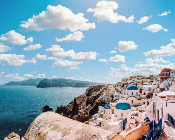 Santorini, Grecja. W jakim języku mówi się w Grecji? Po grecku! Białe domy, niebieskie kopuły i morze.