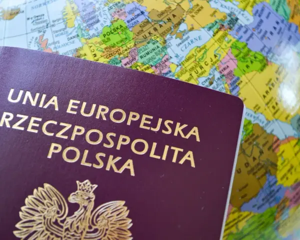Paszport Rzeczypospolitej Polskiej na tle globu. Dowiedz się, ile jest ważny paszport tymczasowy i zaplanuj podróż.