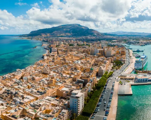 Widok na Trapani, Sycylia. Miasto z widokiem na turkusowe morze i góry. Zobacz, co warto zobaczyć w Trapani: port z luksusowym rejsem i zabytkowymi żaglowcami.
