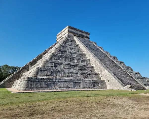 Piramide Kukulkana w Chichen Itza, jeden z Nowych Siedmiu Cudów Świata, majestatycznie wznosi się na tle błękitnego nieba.