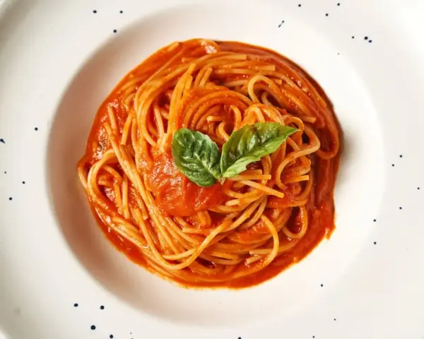 Pyszne spaghetti z sosem pomidorowym i bazylią. Prawdziwa **Italia na talerzu**, która rozpływa się w ustach.