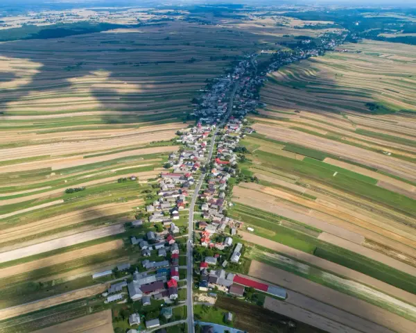 Długa wieś w Polsce, otoczona polami o różnych kolorach, tworząca mozaikę krajobrazu. Może to najpiękniejsza wieś w Polsce?