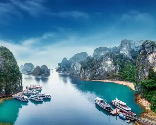 Zatoka Ha Long we Wietnamie z łodziami i skalistymi wyspami.