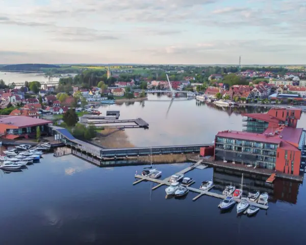 Widok z lotu ptaka na nowoczesny hotel i przystań jachtową na Mazurach.