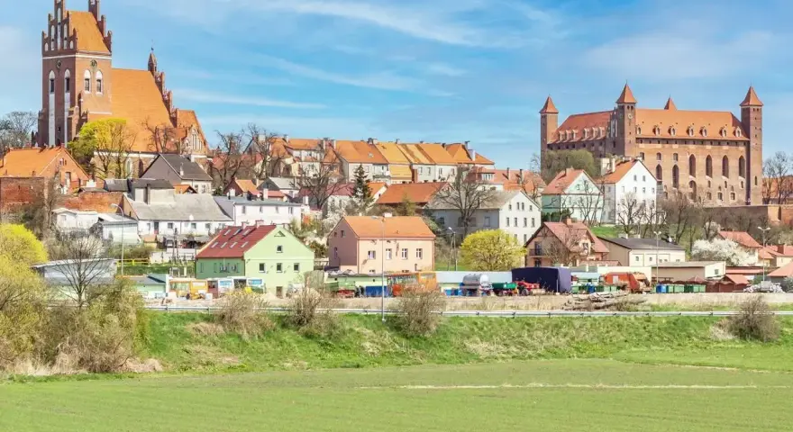 Zamek w Gniewie - ciekawostki. Imponująca twierdza i urokliwe miasteczko na tle błękitnego nieba.