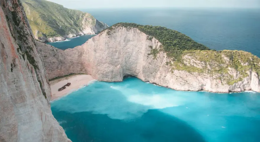 Zatoka Wraku na Zakynthos z turkusową wodą i klifami.