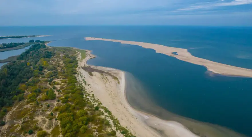 Piaszczysta mierzeja i zalesione wybrzeże tworzą malownicze, ciekawe miejsca nad morzem.