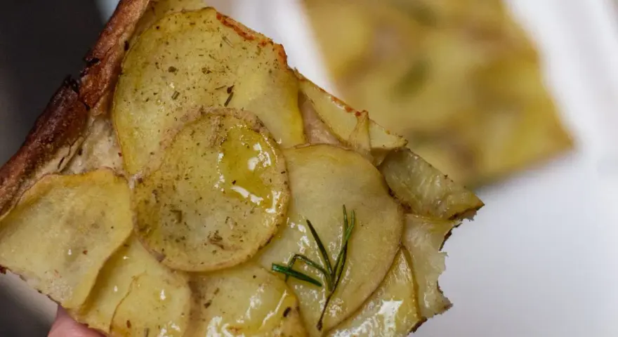 Pyszna pizza ziemniaczana z rozmarynem, idealna odpowiedź na pytanie co zjesc w Rzymie.