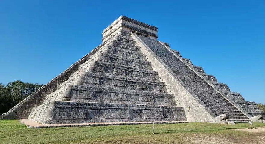 Piramide Kukulkana w Chichen Itza, jeden z Nowych Siedmiu Cudów Świata, majestatycznie wznosi się na tle błękitnego nieba.