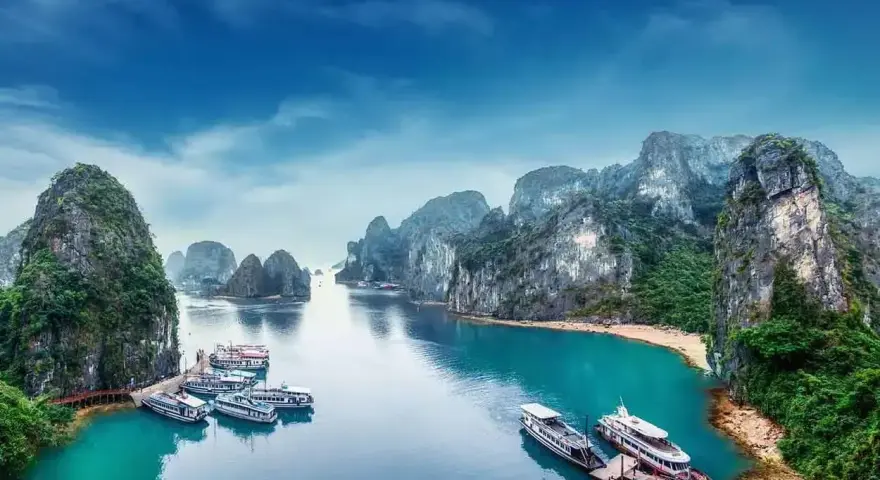 Zatoka Ha Long we Wietnamie z łodziami i skalistymi wyspami.