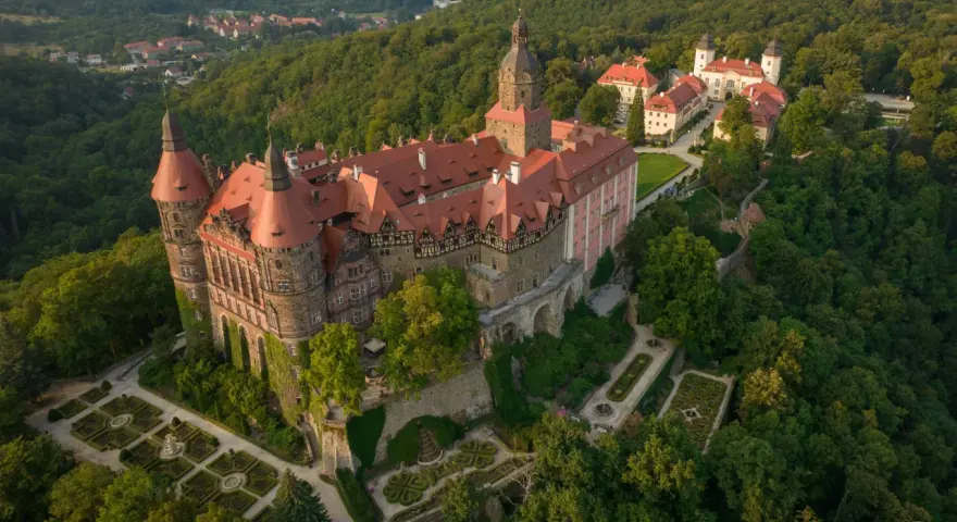 Zamek Książ z lotu ptaka, otoczony lasem. Warto zaplanować cały dzień, by w pełni docenić jego piękno.