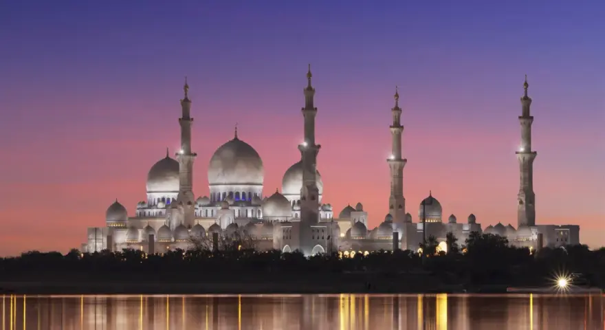 Wspaniały meczet oświetlony nocą, odbijający się w wodzie. Idealny widok, kiedy jest Ramadan.