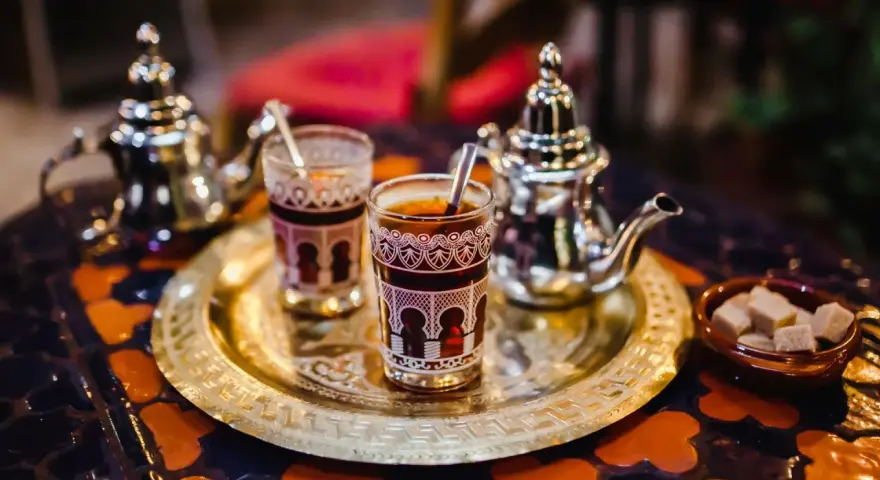 Tradycyjna herbata miętowa z cukrem, serwowana w ozdobnych szklankach i srebrnym imbryku. Idealna na czas Ramadanu, gdy pytamy "ramadan co to".