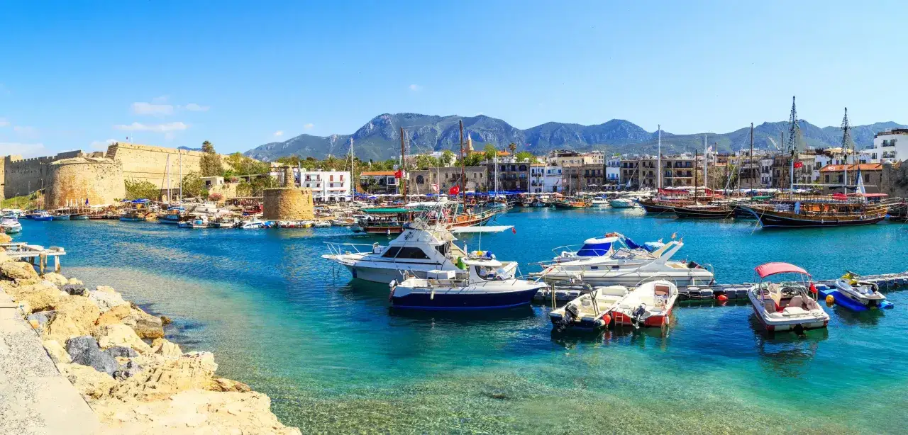 Port Kyrenia, zamek i łodzie. Czy to cypr grecki czy turecki? Woda krystalicznie czysta, góry w tle.