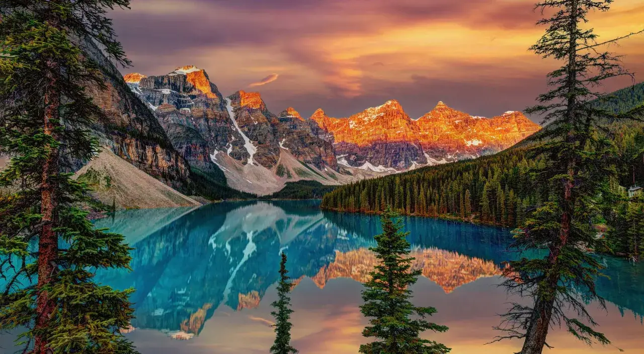 Kanada słynie z zapierających dech w piersiach krajobrazów. Jezioro Moraine w Parku Narodowym Banff, otoczone ośnieżonymi szczytami i lasami, odbija się w turkusowej wodzie.