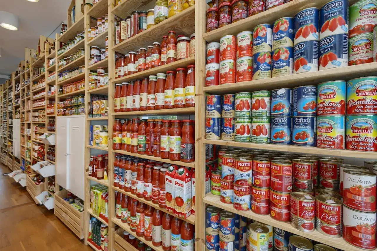 Półki pełne przetworów pomidorowych i sosów, idealne dla szukających najtańszych supermarketów we Włoszech.