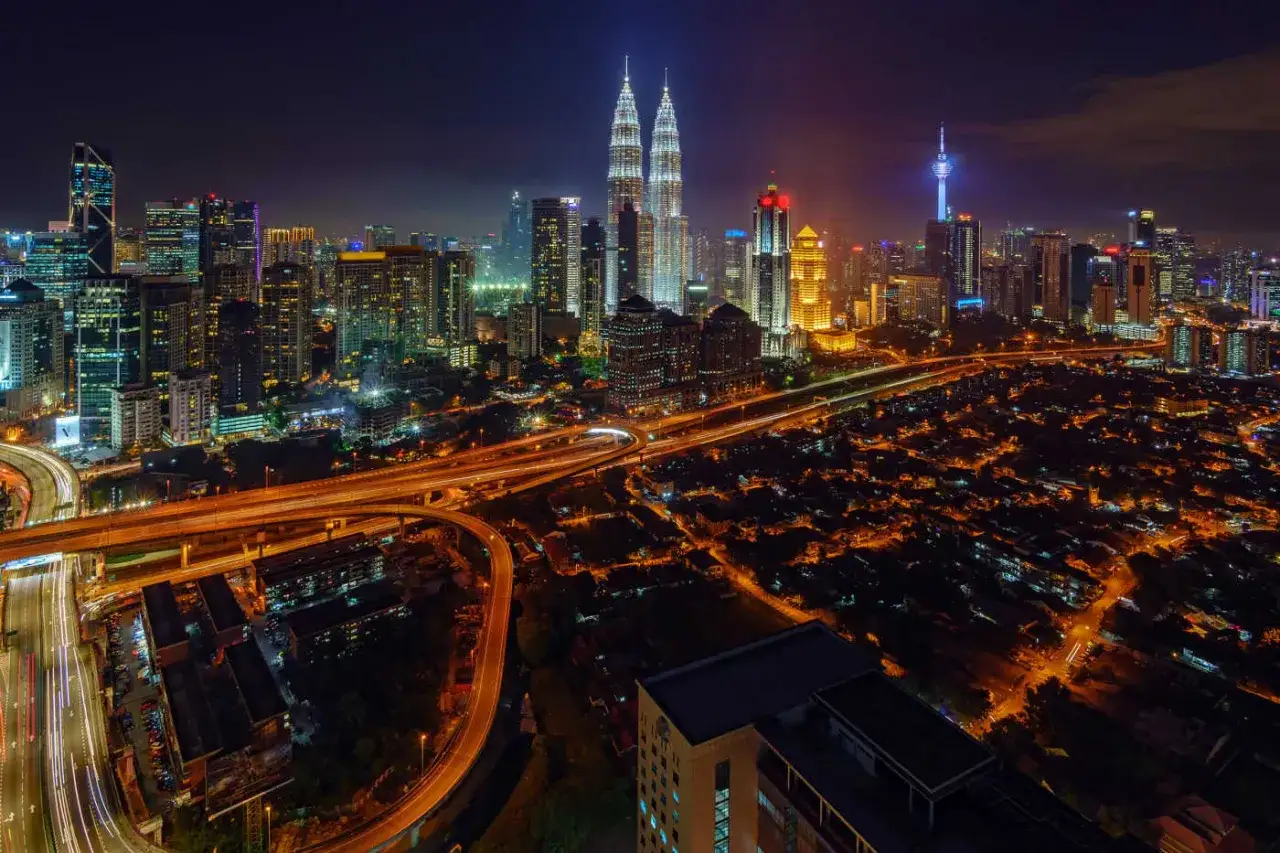 Nocny widok na Kuala Lumpur, jedno z 10 największych miast świata, z wieżami Petronas i oświetlonymi autostradami.