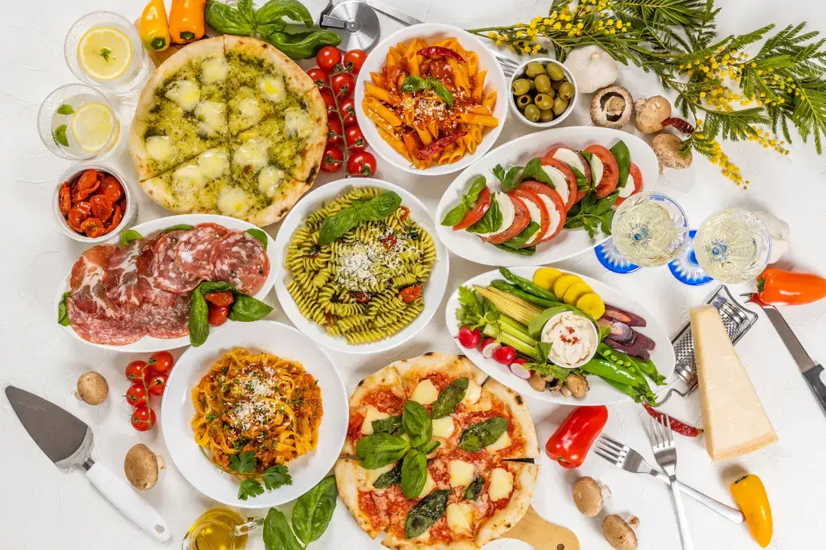 Prawdziwa uczta: pizza, makarony, sałatka caprese, wędliny i warzywa. To wszystko to italia na talerzu!