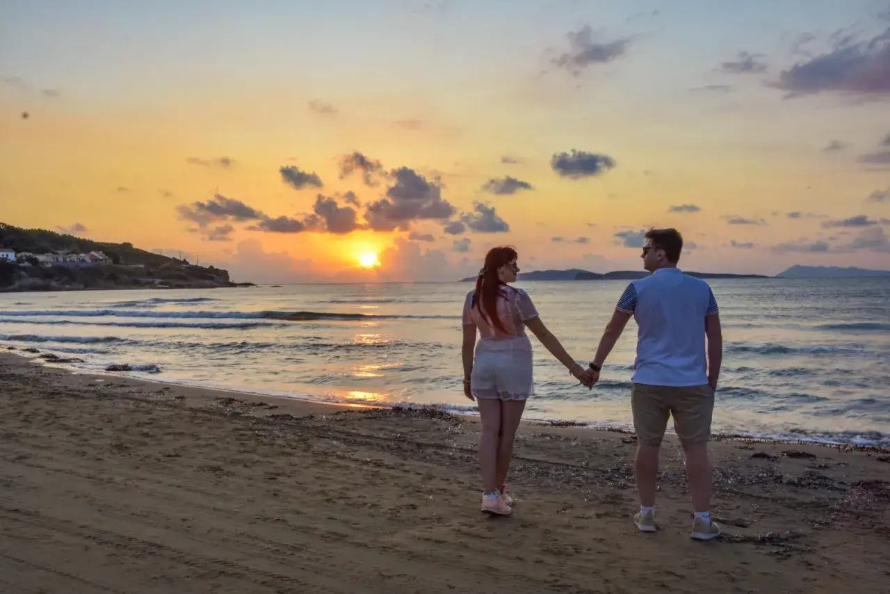 Para zakochanych na plaży, piękny zachód słońca. Korfu pogoda wrzesień idealna na romantyczny wieczór.