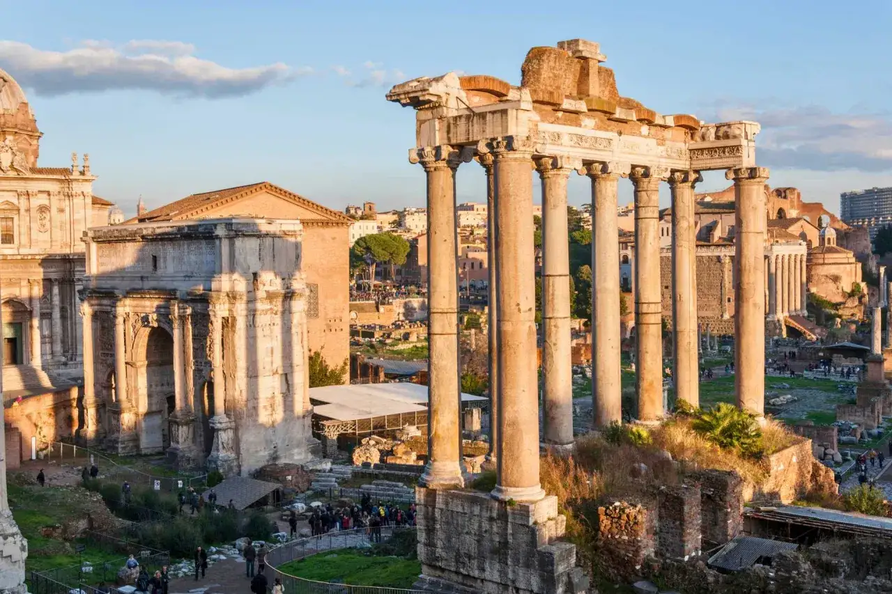 Starożytne ruiny Forum Romanum, idealne na intensywny rzym w 3 dni. Kolumny i łuk triumfalny w złotym świetle.