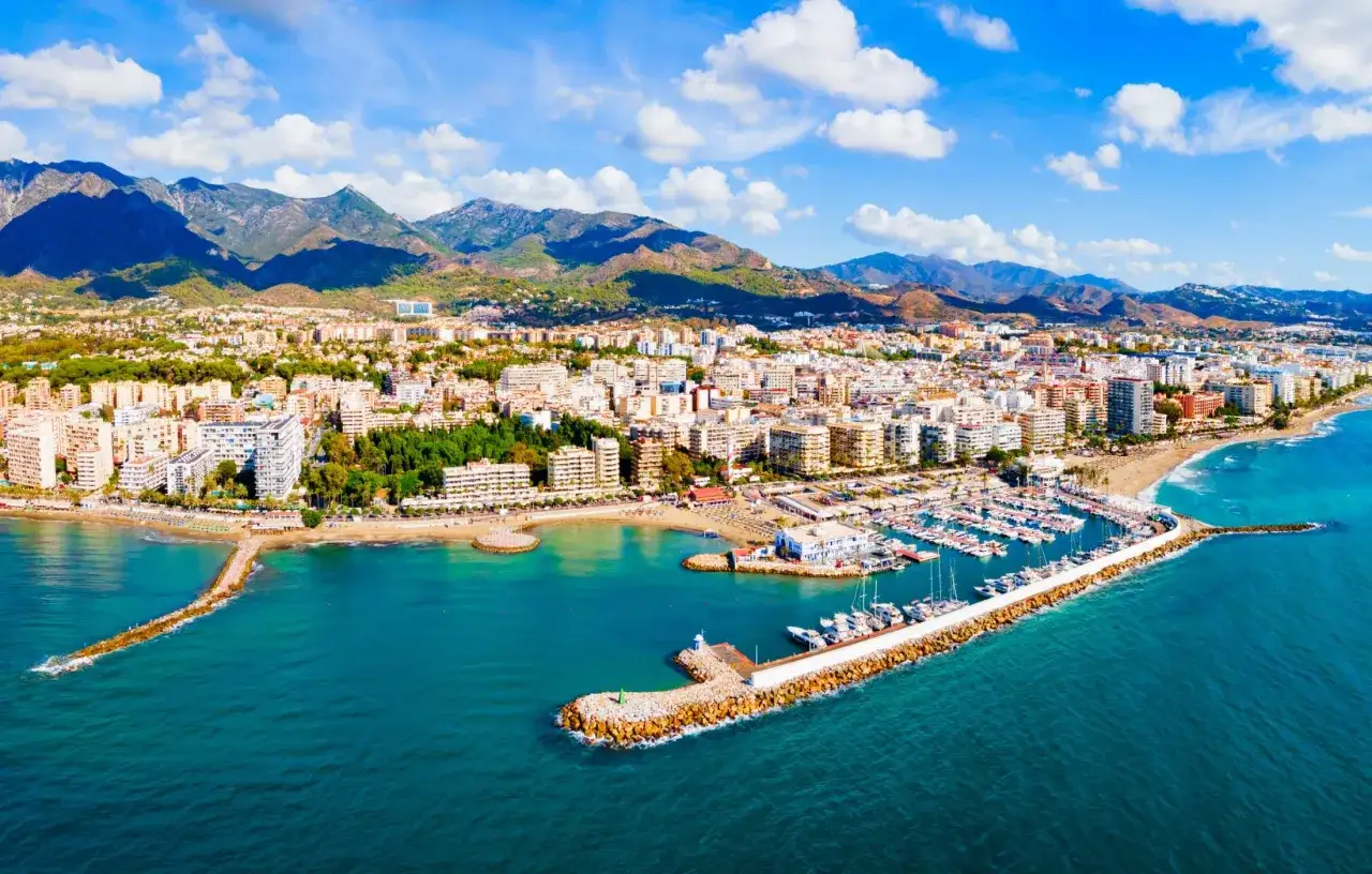 Malownicze wybrzeże z górami w tle. Marina pełna jachtów, plaże i białe budynki to główne costa del sol atrakcje.