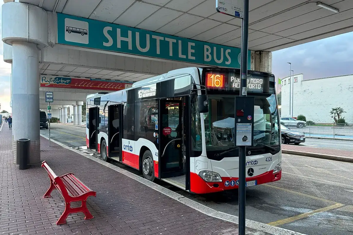 Autobus wahadłowy z lotniska do centrum miasta. Czerwona ławka czeka na pasażerów.