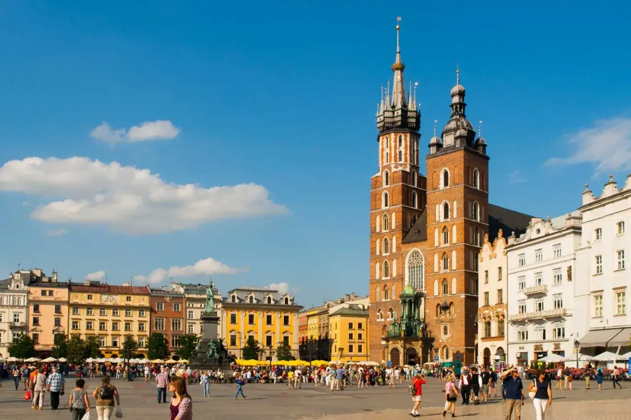 Tłum ludzi na Rynku Głównym w Krakowie, w tle Bazylika Mariacka. Idealne miejsce na weekend w Krakowie.